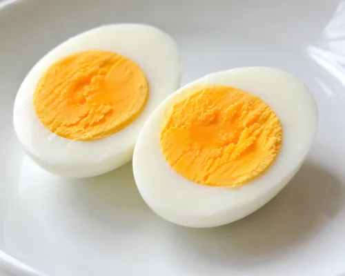 hard boiled egg cut in half white plate close up